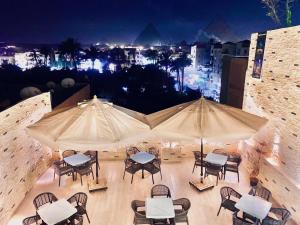 a group of tables and chairs with umbrellas at Crown pyramids hotel in Cairo