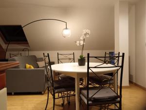 a dining room table with chairs and a lamp at Le Bollwiller Piscine Jacuzzi Vignoble in Bollwiller