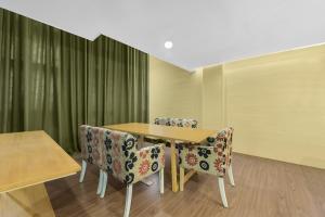 a dining room with a wooden table and chairs at Sunday Hotel Subang in Subang Jaya