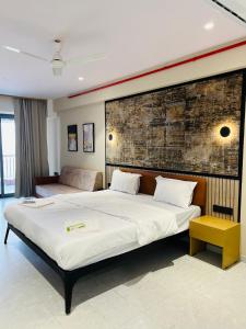 a bedroom with two beds and a brick wall at Hotel Presidency in Surat