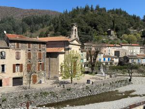 a village with a stone wall and a church at Chez Julie in Valleraugue