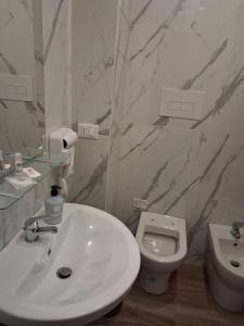 a white bathroom with a sink and a toilet at NaMi in Battipaglia