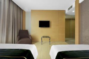 a room with two beds and a chair and a tv at Sunday Hotel Subang in Subang Jaya +36 photos