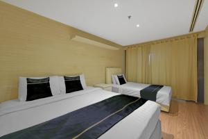 two beds in a hotel room with two at Sunday Hotel Subang in Subang Jaya