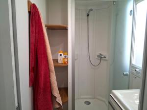 a bathroom with a shower and a red towel at ZEcamping 3 étoiles avec piscine chauffée en pleine nature in Belmont-sur-Rance