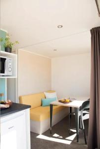 a living room with a couch and a table at ZEcamping 3 étoiles - piscine chauffée haute saison in Antonne-et-Trigonant
