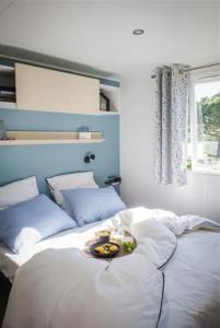 a bed with a plate of food on top of it at ZEcamping 3 étoiles - piscine chauffée haute saison in Antonne-et-Trigonant