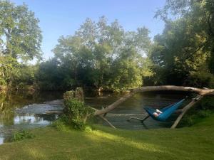 a person laying in a hammock next to a river at ZEcamping 3 étoiles - piscine chauffée haute saison in Antonne-et-Trigonant +32 photos
