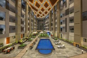 an image of therium of a building with a swimming pool at Protea Hotel by Marriott Kinshasa in Kinshasa