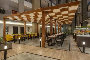a restaurant with tables and chairs in a building at Protea Hotel by Marriott Kinshasa in Kinshasa
