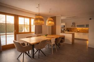 a kitchen and dining room with a wooden table and chairs at Villa mit Pool und Garten in Thalheim bei Wels