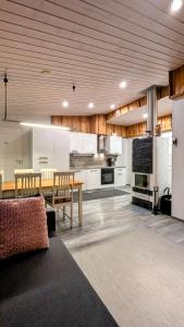 a living room with a table and a kitchen at North Frontier Cabins in Saariselka