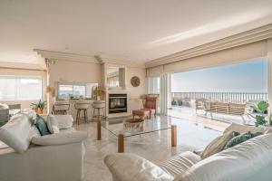 a living room with white furniture and a view of the ocean at Luxury Penthouse Ashdod, Sea View, 5 Bedrooms, Rooftop in Ashdod