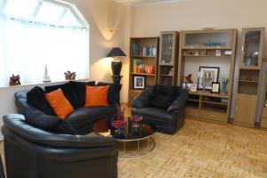 a living room with a black leather couch and a table at Dehiwala Holiday Villa in Dehiwala