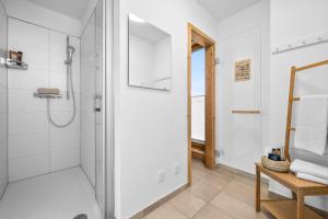 a white bathroom with a shower and a toilet at Annas Heimat am Meer in Kappeln +23 photos