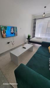 a living room with a couch and a tv at Home Away in Ongata Rongai 