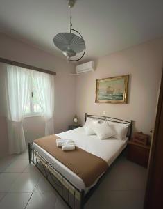 a bedroom with a large bed with white pillows at The Kefalonian Divarata House in Kefalonia