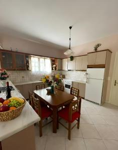 a kitchen with a table with a bowl of fruit on it at The Kefalonian Divarata House in Kefalonia