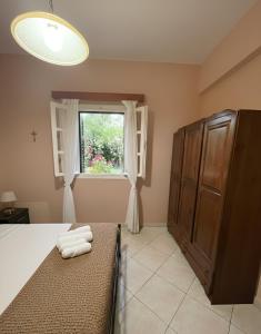 a bedroom with a bed and a window at The Kefalonian Divarata House in Kefalonia