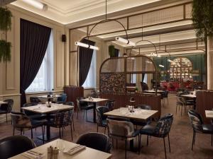 a restaurant with tables and chairs and a chandelier at The Met Hotel Leeds - Newly Refurbished in Leeds