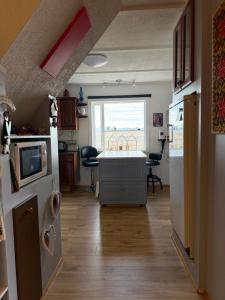 a kitchen with a island in the middle of a room at Laufás Guesthouse in Hellissandur