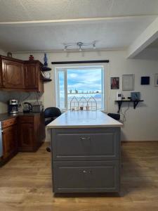 a kitchen with a island in the middle of a room at Laufás Guesthouse in Hellissandur