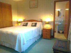 a bedroom with a bed and a bathroom with a sink at Collin Hill House in Castle Douglas