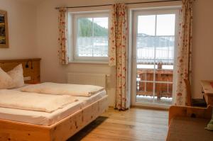 a bedroom with two beds and a large window at Bauernhof Krahlehen - B&B - Apartments in Filzmoos