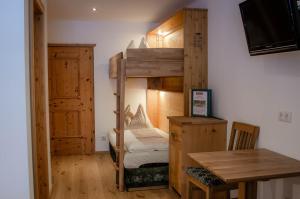 a room with a bunk bed and a table at Bauernhof Krahlehen - B&B - Apartments in Filzmoos