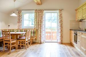 a kitchen with a table and chairs and a window at Bauernhof Krahlehen - B&B - Apartments in Filzmoos