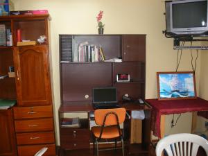 een kamer met een bureau, een laptop en een computer bij Edificio Danny Javier in Quito
