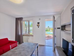 a living room with a red couch and a table at Residence Green Park in Torri del Benaco