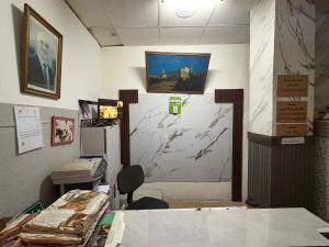 ein Büro mit einem Schreibtisch und einer Wand mit einem Gemälde in der Unterkunft man -soor in Amman