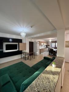 a large living room with a green couch in the middle at Tropical Beach in Eforie Sud