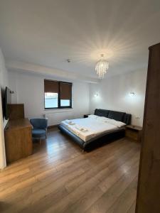 a bedroom with a bed and a chair and a chandelier at Tropical Beach in Eforie Sud