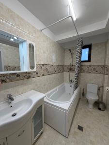 a bathroom with a sink and a tub and a toilet at Tropical Beach in Eforie Sud +42 photos