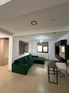 a living room with a green couch and a television at Tropical Beach in Eforie Sud