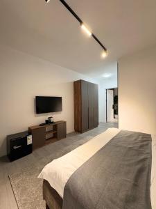a bedroom with a bed and a flat screen tv at Avenue Hotel in Almaty