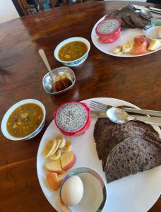 a wooden table with three plates of food on it at Bagaan Villa Homestay in Ilām