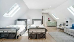 a attic bedroom with two beds and a couch at Villa Mist Manor in East Hampton +38 photos