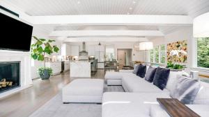 a living room with white furniture and a fireplace at Villa Mist Manor in East Hampton