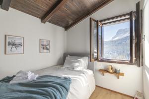a bedroom with a bed and a window with a mountain view at Ciasa Remo 2 by WelcHome in San Vito di Cadore