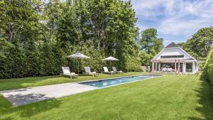 a backyard with a swimming pool and a house at Villa Mist Manor in East Hampton