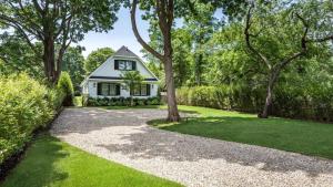a house with a gravel driveway and trees at Villa Mist Manor in East Hampton