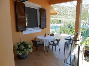 a dining room with a table and chairs on a balcony at Aristoula House in Sivota
