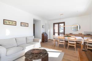 a living room with a white couch and a table at Ciasa Remo 2 by WelcHome in San Vito di Cadore