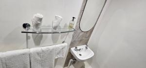 a white bathroom with a sink and a mirror at Ellerbrook House in Windermere +30 photos