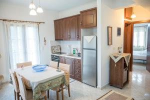 a kitchen with a table and a refrigerator at Lesvos Garden Retreats - Mountain Voyage Residences in Vatoússa
