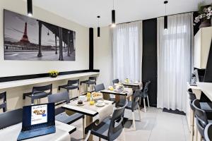 a restaurant with tables and chairs and a laptop at Modern Hotel in Paris