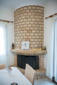 a brick fireplace with a table in front of it at Lesvos Garden Retreats - Mountain Voyage Residences in Vatoússa +47 photos